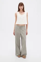 Pantalón de algodón color gris, de tiro medio y corte holgado tipo baggy, con bolsillos laterales y cordón ajustable en la cintura.