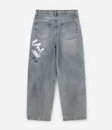 Pantalón de jeans para hombre, modelo super baggy, color celeste desgastado, con estampa de grafiti en negro en ambas piernas. Presenta cintura con trabilla, cierre tradicional y bolsillos.