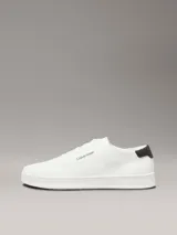Zapatillas de perfil bajo Calvin Klein confeccionadas en tejido de punto transpirable color blanco. Presentan un diseño minimalista con puntera revestida, suela de goma blanca y detalle de trabilla trasera en piel color negro con el logo de la marca en el lateral y la mediasuela.