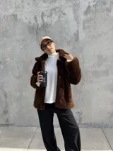 Campera de textura tipo peluche en color marrón, con cuello solapa, cierre frontal y diseño holgado.