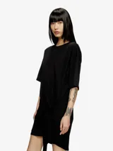 Vestido blanco de manga corta, estilo camiseta, confeccionado en jersey de algodón orgánico. Presenta un lazo frontal ajustable que genera un efecto drapeado y un recorte bordado en el frente.