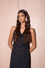 Vestido largo negro con estampado de lunares blancos, confeccionado en jersey con lurex y encaje. Presenta escote en V profundo, tirantes finos y detalles de encaje en el pecho y el ruedo.
