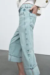 Jeans capri de tiro medio con cintura con trabillas y cinco bolsillos. Presenta pespuntes marcados a contraste y bajo acabado en vuelta.