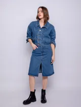 Campera corta de jean azul, con cuello camisero, botones metálicos frontales y bolsillos con tapa en el pecho. Presenta un calce holgado y mangas largas con puños abotonados.