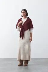 Vestido midi de punto en color gris, con diseño de tejido acanalado vertical, cuello redondo y mangas largas. Presenta una silueta recta y fluida.