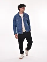 Campera de jean azul con cuello clásico, cierre frontal con botones metálicos, bolsillos con solapa abotonada en el pecho y bolsillos laterales.