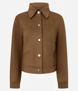 Chaqueta de corte recto confeccionada en suede sintético color marrón. Presenta cuello estilo camisa, cierre frontal con botones metálicos, mangas largas con puños ajustados y bolsillos embutidos.