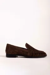 Mocasín de gamuza color bordó con detalle de frunces en la puntera y suela plana de goma negra.
