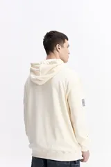 Canguro con capucha y cordones ajustables, de corte holgado y bolsillo frontal tipo canguro. Presenta un pequeño logo estampado en el pecho.