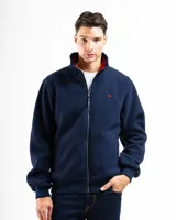 Campera de polar color azul marino con cierre frontal y cuello alto. El interior del cuello es de tela a cuadros roja y azul. Presenta un pequeño bordado de montaña en color rojo en el pecho. Tiene puños y cintura de elástico.