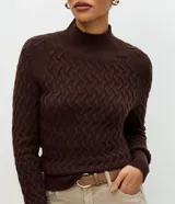 Suéter de punto color crema con textura en zigzag, cuello alto y mangas largas con puños ajustados.