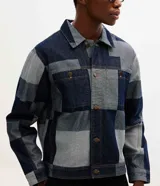 Campera de jacquard de algodón con diseño patchwork de cuadros en tonos azules. Presenta cuello inglés, cierre frontal con botones metálicos, mangas largas y bolsillos delanteros.