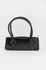 Cartera tipo baguette color negro con textura efecto cocodrilo, diseño alargado, doble asa de mano y cierre superior.