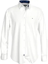Camisa blanca de algodón con elastano, corte regular, cuello abotonado, cierre con botones, manga larga y logo de Tommy Hilfiger bordado en el pecho.