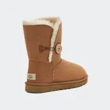 Botas cortas UGG modelo Bailey Button color marrón, con interior de piel de oveja color crema y botón de madera con el logo de la marca.