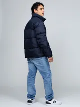 Campera puffer azul marino de cuello alto, acolchada y con cierre frontal de cremallera. Presenta bolsillos laterales con ojal y el logo bordado de la marca en el pecho.