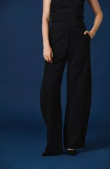 Pantalón de vestir negro de corte ancho y silueta fluida, con cintura definida y bolsillos laterales.