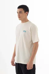 Remera color crudo de algodón con estampado azul de la banda Oasis, con logo, dibujos de los integrantes y referencias a sus canciones.