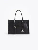 Bandolera tipo tote de cuero vacuno color negro, con doble asa superior, bolsillo frontal con cierre y detalle de llavero mosquetón con dije de corazón.