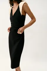Vestido midi de escote en pico y diseño sin mangas con hombreras en contraste color crema. Presenta cintura entallada con frunces laterales, cierre trasero con cremallera oculta y abertura en el bajo de la espalda.