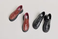Mocasines con plataforma de goma negra, confeccionados en lona con estampa a cuadros en tonos violeta, amarillo y beige, y detalle de elásticos laterales ocultos.