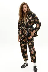 Pantalón de denim con corte barrel relajado y tiro medio, confeccionado en algodón con spandex. Presenta un estampado floral integral sobre fondo negro.