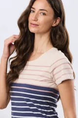 Remera de manga corta y cuello redondo, confeccionada en algodón con diseño de rayas horizontales en tono beige, rosado y azul marino.