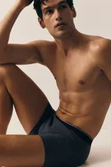 Pack de tres calzoncillos tipo trunk de punto elástico de algodón en gris y negro, con cintura elástica con logo en blanco y costuras planas. Confeccionados con tecnología Lycra® Xtra Life™.