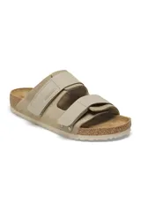 Sandalias Birkenstock Uji de cuero gamuzado color taupe, con plantilla anatómica de corcho y doble tira con hebilla ajustable.