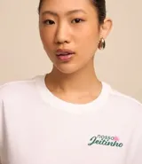 Remera blanca alargada de algodón, con cuello redondo y mangas cortas. Presenta una estampa grande en la espalda con iconos de la cultura brasileña.