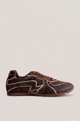 Championes deportivos color marrón con diseño de líneas onduladas en tono claro, cordones al tono y suela de goma.