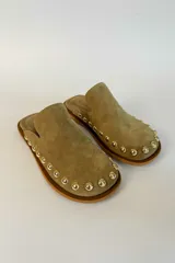 Sueco de gamuza color marrón con detalle de tachas metálicas doradas alrededor de la suela y punta redonda.