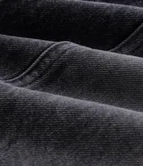 Pantalón de jean estilo baggy balloon color negro, con diseño amplio, efecto desgastado, recortes laterales estructurados, bolsillos funcionales y cierre frontal con botón y cremallera.