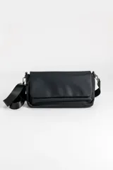 Bandolera de cuero sintético negro con solapa frontal y correa ajustable.