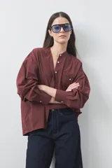 Camisa de manga larga color bordó con cuello mao, silueta relajada, sisa caída y bolsillo frontal aplicado.
