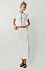 Falda midi tubo de punto color blanco, de corte recto y cintura elástica.