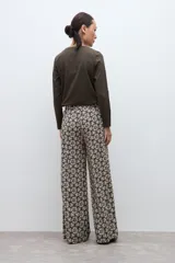 Pantalón de corte recto y tiro alto con estampado geométrico en tonos verde oliva y crema.