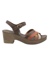 Sandalias de cuero RKF modelo Dalia, con tacón ancho efecto corcho y plataforma. Posee tiras cruzadas en la parte delantera en tonos marrón, terracota, tostado y beige, y tira al tobillo con hebilla metálica.