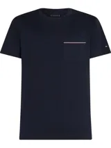 Remera de manga corta Tommy Hilfiger en color azul marino, con cuello redondo y bolsillo de parche en el pecho que presenta un detalle de línea horizontal con los colores distintivos de la marca. Incluye el logo de la bandera bordado en la manga izquierda.