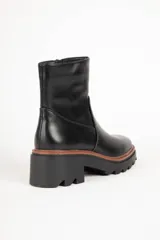 Bota corta de cuero sintético color marrón, con punta redonda, cierre lateral y suela tipo tractor de 6 cm.