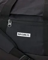 Bolso de viaje tipo duffle de Rip Curl, modelo Packable Duffle 35L Icons, en color negro. Cuenta con abertura principal en forma de U, bolsillo frontal con cierre, asas de transporte superiores y correa de hombro ajustable y extraíble. Incluye detalle de etiqueta con el logo de la marca en el frente.