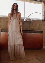 Vestido largo con diseño halter, estampado de rayas verticales en tonos celestes, naranjas y blancos, con detalle de volantes en el escote y abalorios en el cuello.