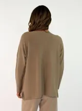 Sweater de punto color verde oliva, con cuello redondo, mangas largas y diseño holgado con costuras visibles en los laterales.