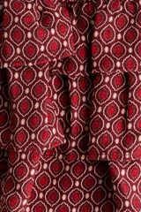 Short pollera de sarga en mezcla de viscosa con estampado geométrico en tonos bordó y blanco. Presenta cintura ancha fruncida y diseño escalonado con volados.