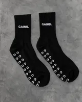 Medias antideslizantes negras de caña media, con la palabra "GAINS" bordada en el empeine en color blanco y patrón de puntos antideslizantes de goma en la planta del pie.