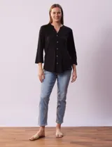 Blusa Ninety color beige con textura, cuello base con escote en V y abertura central con botones. Tiene un bolsillo en el pecho y mangas 3/4 regulables con presilla y botón.