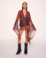 Minivestido cruzado con estampado animal print en tonos naranja, marrón y negro. Tiene escote en V pronunciado, mangas largas acampanadas y falda ajustada.