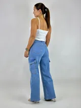 Pantalón jean celeste de tiro alto, corte wide leg y bolsillos cargo laterales.