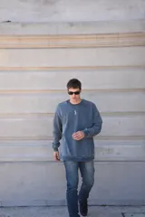 Buzo azul de algodón con cuello redondo y puños acanalados. Presenta un pequeño logo bordado en el centro del pecho.