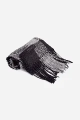 Bufanda tejida a cuadros color gris y negro con flecos en los extremos.